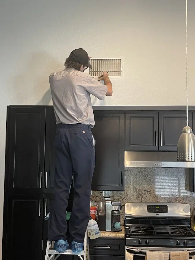 Technician inspecting an air vent during HVAC service in Sault Ste. Marie